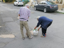 Куриоз: Двама възрастни мъже сами запълват дупките по улицата около блока си