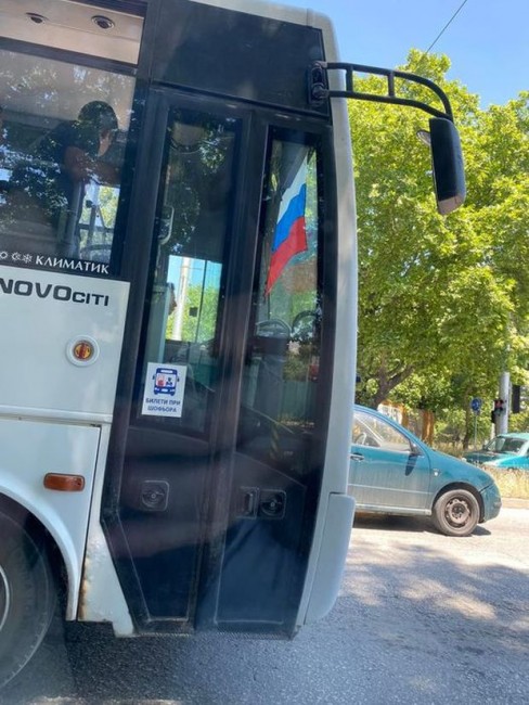 Разпънато руско знаме на предното стъкло на автобус на градския