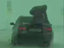 Червен код за безумие на пътя: Мъж скача върху багажника на кола за повече сцепление в снега