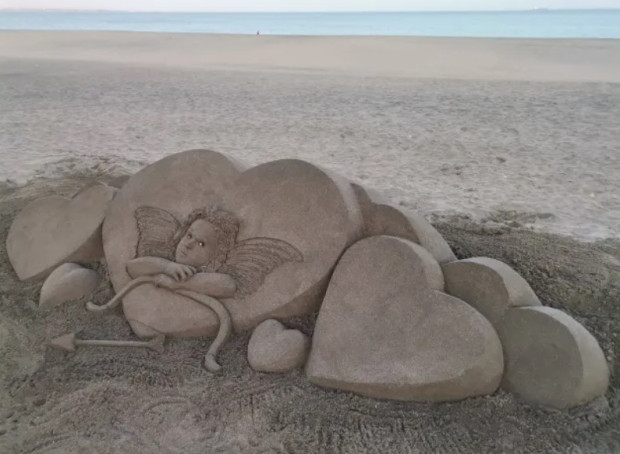 TD Пясъчна скулптура на Купидон се появи на плажа в Бургас