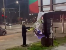 Мъж разкъса билборд, свързан с годишнина от войната в Украйна