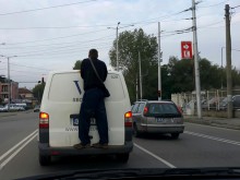 Инкасо бус пътува с пътник на задната броня