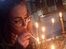 Девойка запали цигара от горяща в църква свещичка