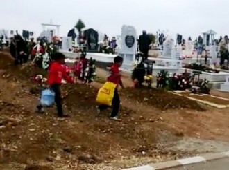Кадри, показващи как мургава тълпа се стича на гробищата, вдига
