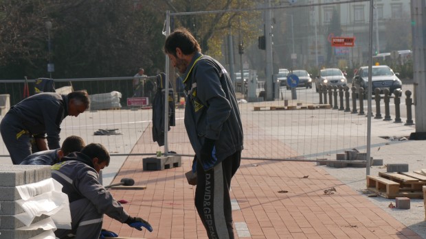 Работници подреждат трасето  по новия тротоар на бул Цар Борис Трети